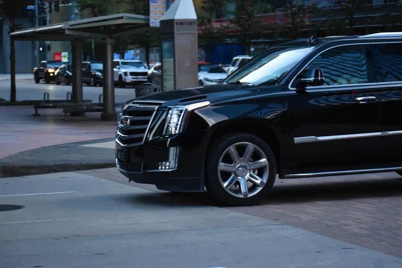A black luxury SUV on a city street at night