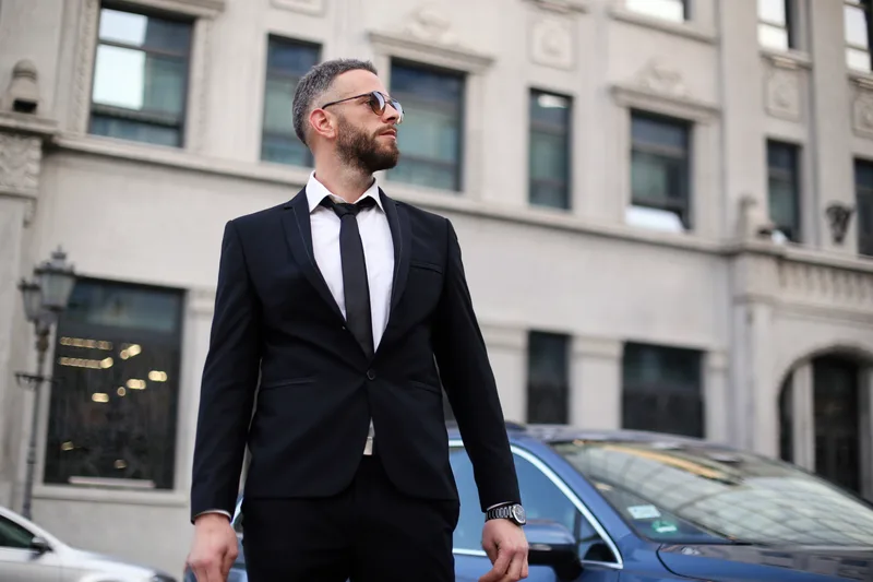 A chauffeured black car in the downtown business district