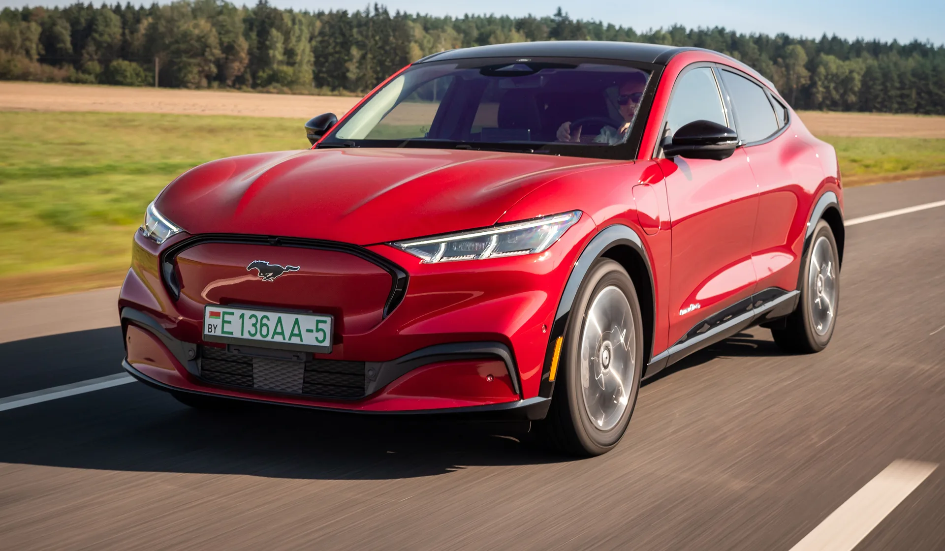 A luxury car in motion on the highway toward the airport