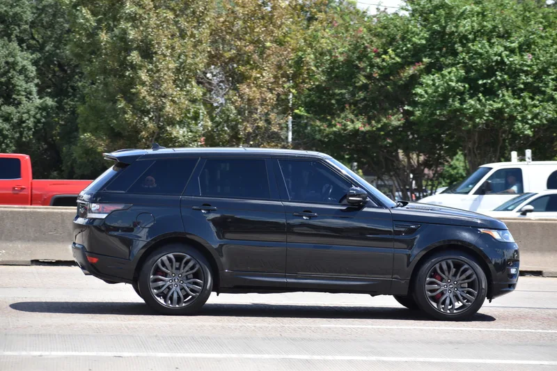 A black sedan on the highway toward the airport