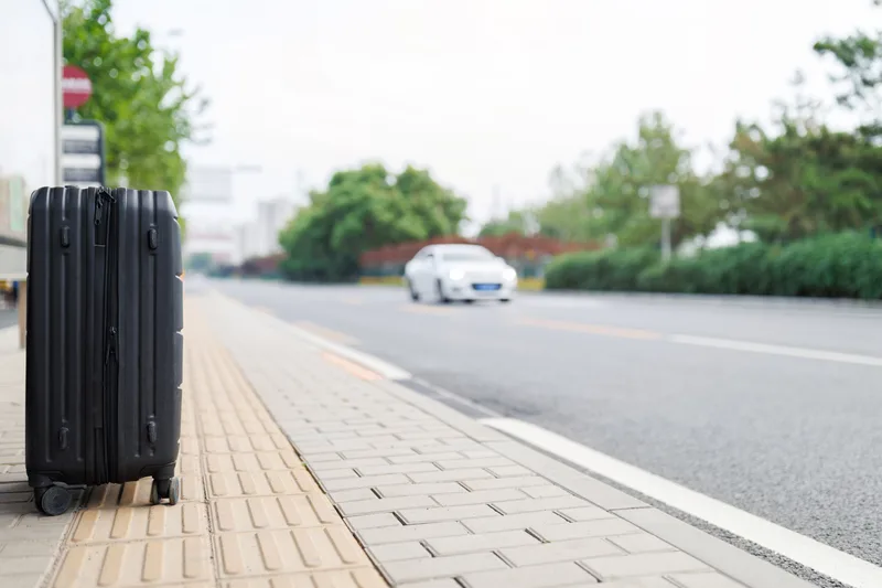 Luggage loaded into a car at the airport curb